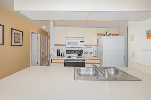 kitchen featuring white appliances, light countertops, and white cabinetry