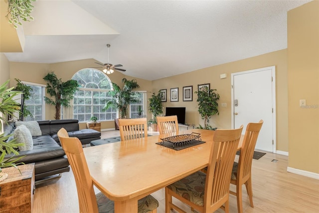 dining room featuring vaulted ceiling, ceiling fan, and light wood-style floors