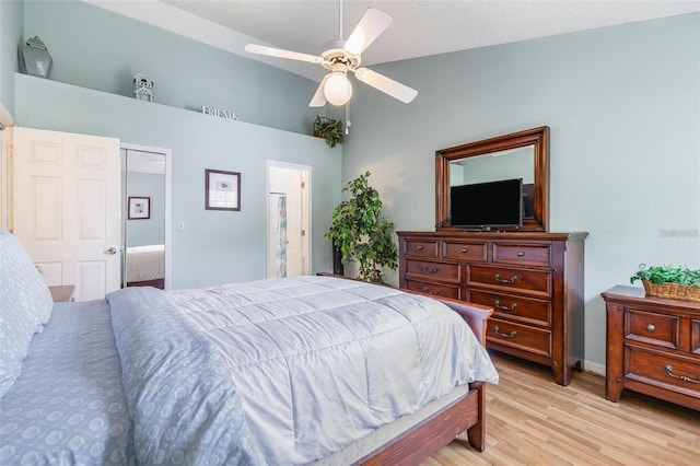 bedroom with light wood-style floors, ensuite bathroom, and ceiling fan