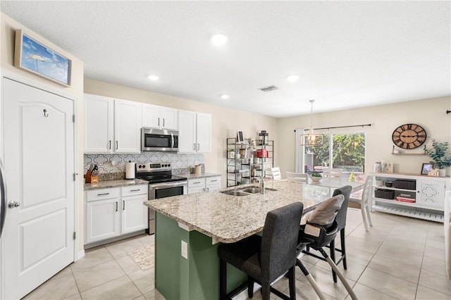 9024 Alba Ln, Kissimmee, FL 34747 - kitchen with stainless steel appliances, light tile patterned flooring, white cabinetry, decorative backsplash, and recessed lighting
