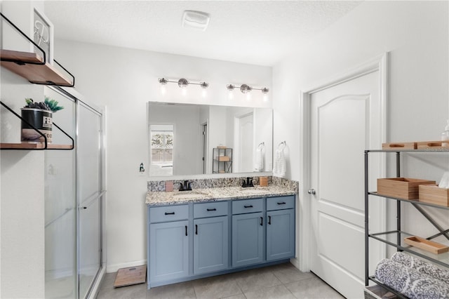9024 Alba Ln, Kissimmee, FL 34747 - bathroom with double vanity, a shower stall, tile patterned flooring, and a textured ceiling
