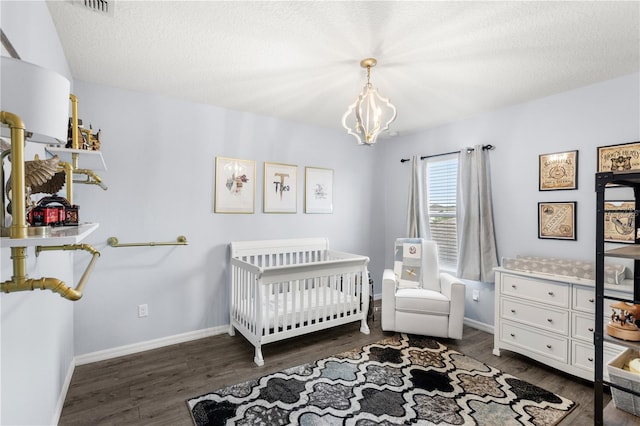 9024 Alba Ln, Kissimmee, FL 34747 - bedroom with dark wood-style flooring, a chandelier, and a crib