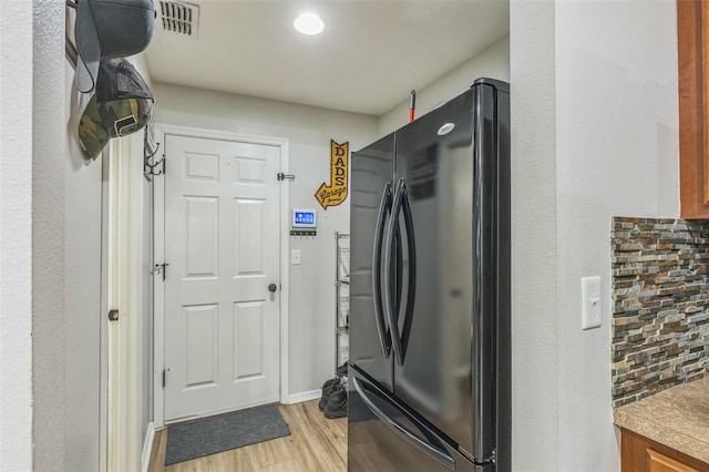 2032 Wavyleaf Ct, Apopka, FL 32712 - kitchen with freestanding refrigerator, light wood-type flooring, brown cabinets, and tasteful backsplash