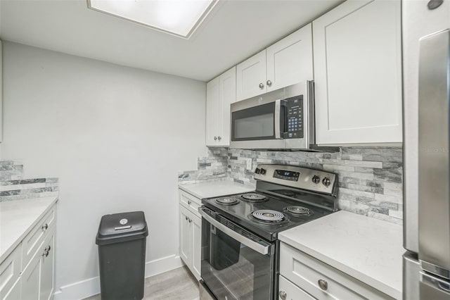 936 Lake Destiny Rd Unit G, Altamonte Springs, FL 32714 - kitchen with appliances with stainless steel finishes, decorative backsplash, and white cabinetry