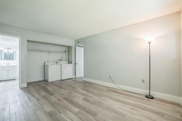 936 Lake Destiny Rd Unit G, Altamonte Springs, FL 32714 - unfurnished living room with independent washer and dryer, light wood finished floors, and a textured ceiling