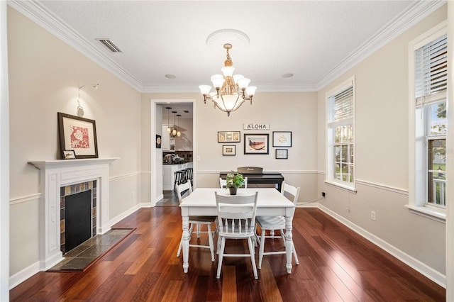 1443 Stone Trl, Enterprise, FL 32725 - dining space featuring a chandelier, ornamental molding, dark wood-type flooring, and a tiled fireplace