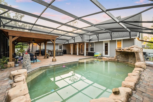 1443 Stone Trl, Enterprise, FL 32725 - pool at dusk featuring an outdoor pool, a patio, ceiling fan, and a lanai