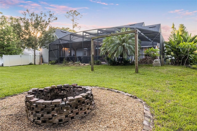 1443 Stone Trl, Enterprise, FL 32725 - yard at dusk with a fenced backyard, an outdoor fire pit, and glass enclosure
