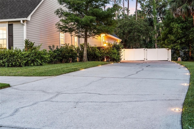 1443 Stone Trl, Enterprise, FL 32725 - view of side of home with a gate, concrete driveway, and roof with shingles