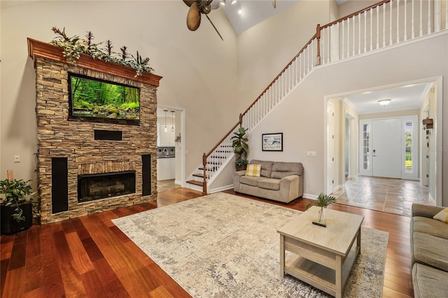 1443 Stone Trl, Enterprise, FL 32725 - living area featuring a ceiling fan, stairway, wood finished floors, a fireplace, and high vaulted ceiling