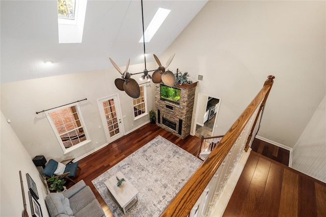 1443 Stone Trl, Enterprise, FL 32725 - living room featuring a skylight, a stone fireplace, high vaulted ceiling, wood finished floors, and ceiling fan