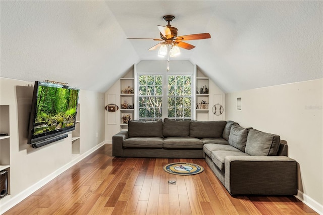 1443 Stone Trl, Enterprise, FL 32725 - living room with lofted ceiling, wood finished floors, a ceiling fan, built in shelves, and a textured ceiling
