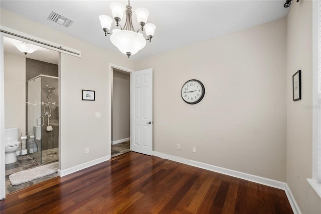 1443 Stone Trl, Enterprise, FL 32725 - unfurnished bedroom featuring wood finished floors, a chandelier, and connected bathroom