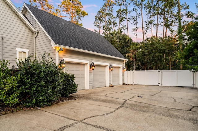 1443 Stone Trl, Enterprise, FL 32725 - garage at dusk featuring a gate and driveway