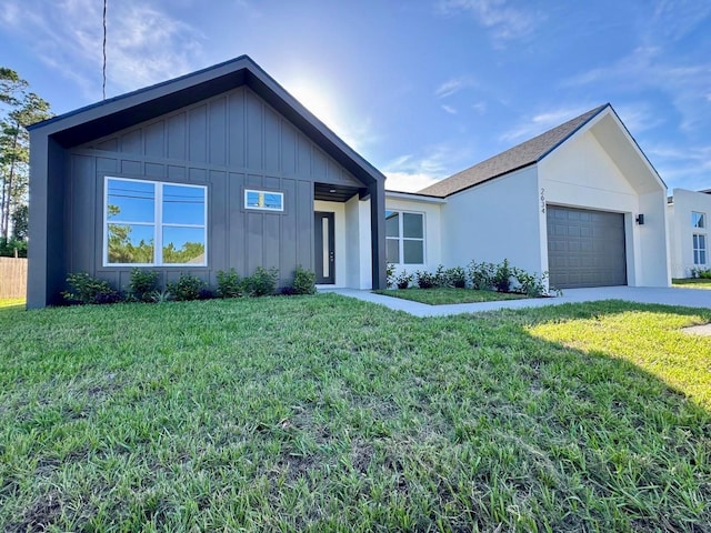 2634 De Groodt Rd SW, Palm Bay, FL 32908 - view of front of home with board and batten siding, a front yard, an attached garage, and driveway