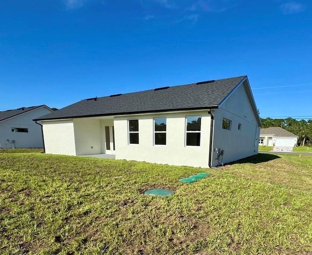 2634 De Groodt Rd SW, Palm Bay, FL 32908 - rear view of property featuring a lawn, stucco siding, and a shingled roof