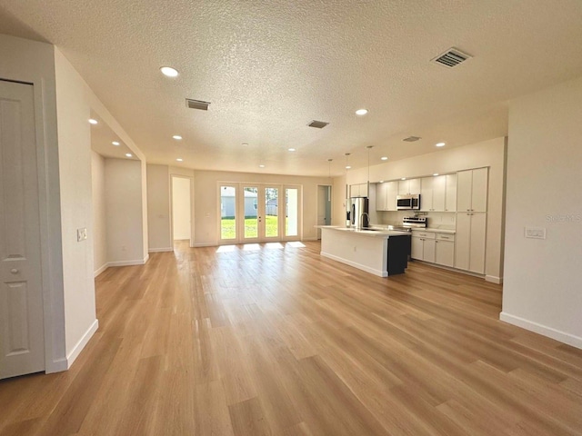 2634 De Groodt Rd SW, Palm Bay, FL 32908 - unfurnished living room featuring light wood-style floors, a textured ceiling, and recessed lighting