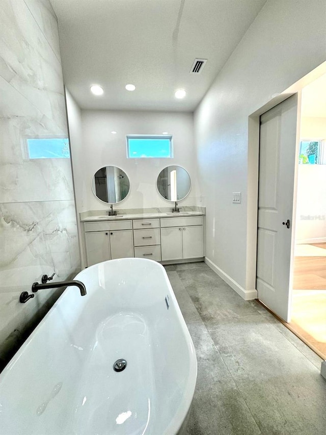 2634 De Groodt Rd SW, Palm Bay, FL 32908 - full bath with a soaking tub, double vanity, concrete flooring, and recessed lighting