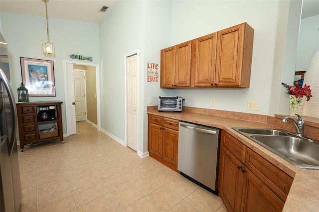2362 Prairie Dunes, Clermont, FL 34711 - kitchen with appliances with stainless steel finishes, a high ceiling, brown cabinetry, hanging light fixtures, and light tile patterned flooring