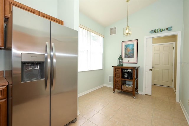 2362 Prairie Dunes, Clermont, FL 34711 - kitchen with stainless steel fridge with ice dispenser, light tile patterned flooring, brown cabinetry, lofted ceiling, and pendant lighting