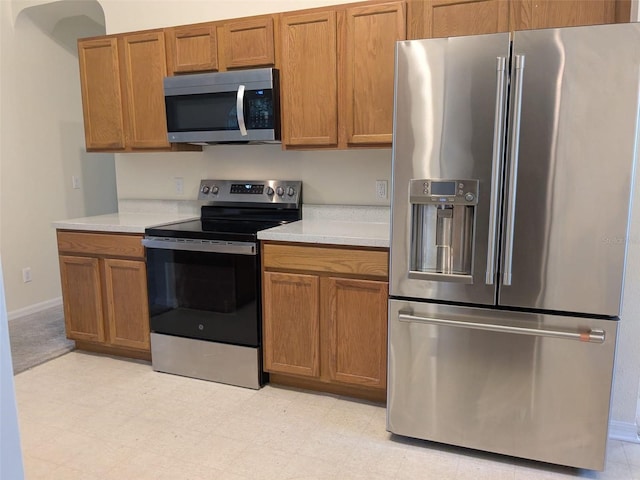 1027 Sheeler Hills Dr, Apopka, FL 32703 - kitchen with appliances with stainless steel finishes, light countertops, and brown cabinets