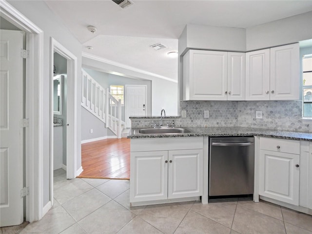 750 Olympic Cir Unit D1, Ocoee, FL 34761 - kitchen with stainless steel dishwasher, light tile patterned floors, white cabinetry, and decorative backsplash