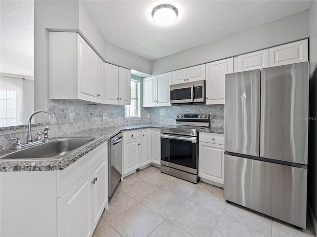 750 Olympic Cir Unit D1, Ocoee, FL 34761 - kitchen featuring appliances with stainless steel finishes, decorative backsplash, light tile patterned floors, and white cabinetry