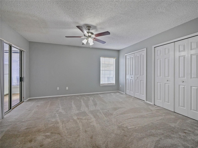 750 Olympic Cir Unit D1, Ocoee, FL 34761 - unfurnished bedroom with carpet floors, two closets, multiple windows, a textured ceiling, and ceiling fan
