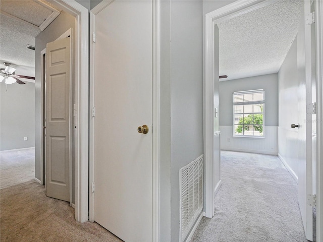 750 Olympic Cir Unit D1, Ocoee, FL 34761 - corridor featuring carpet floors, a textured ceiling, and wainscoting