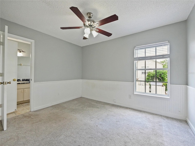 750 Olympic Cir Unit D1, Ocoee, FL 34761 - empty room featuring a wainscoted wall, light carpet, a textured ceiling, and a ceiling fan