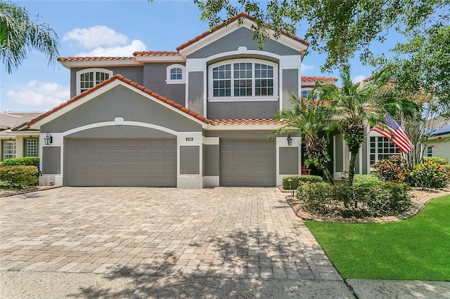 2388 Baronsmede Ct, Winter Garden, FL 34787 - mediterranean / spanish-style home featuring a tile roof, stucco siding, decorative driveway, and an attached garage