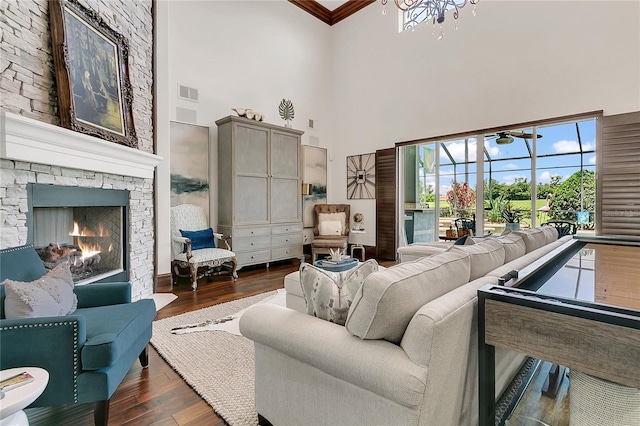 2388 Baronsmede Ct, Winter Garden, FL 34787 - living area featuring a towering ceiling, hardwood / wood-style flooring, a stone fireplace, and ornamental molding