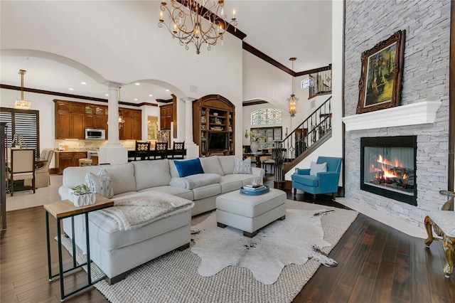 2388 Baronsmede Ct, Winter Garden, FL 34787 - living area featuring decorative columns, wood-type flooring, a towering ceiling, arched walkways, and ornamental molding
