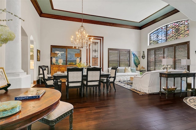 2388 Baronsmede Ct, Winter Garden, FL 34787 - dining space featuring a towering ceiling, crown molding, arched walkways, wood-type flooring, and a chandelier