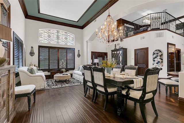 2388 Baronsmede Ct, Winter Garden, FL 34787 - dining space with arched walkways, a high ceiling, a chandelier, ornamental molding, and dark wood-style flooring