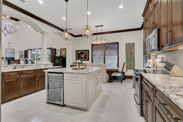 2388 Baronsmede Ct, Winter Garden, FL 34787 - kitchen with appliances with stainless steel finishes, decorative columns, beverage cooler, plenty of natural light, and crown molding
