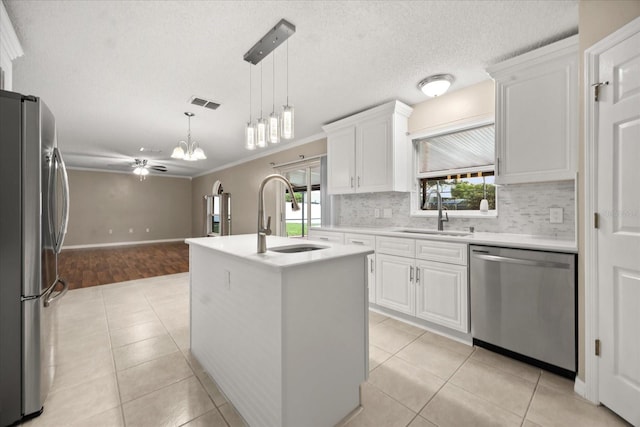 2725 White Magnolia Loop, Clermont, FL 34711 - kitchen featuring stainless steel appliances, plenty of natural light, a ceiling fan, light tile patterned floors, and ornamental molding