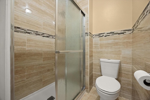 2725 White Magnolia Loop, Clermont, FL 34711 - bathroom featuring tile walls, a shower stall, and tile patterned flooring