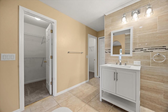 2725 White Magnolia Loop, Clermont, FL 34711 - bathroom with vanity, a spacious closet, and tile patterned floors