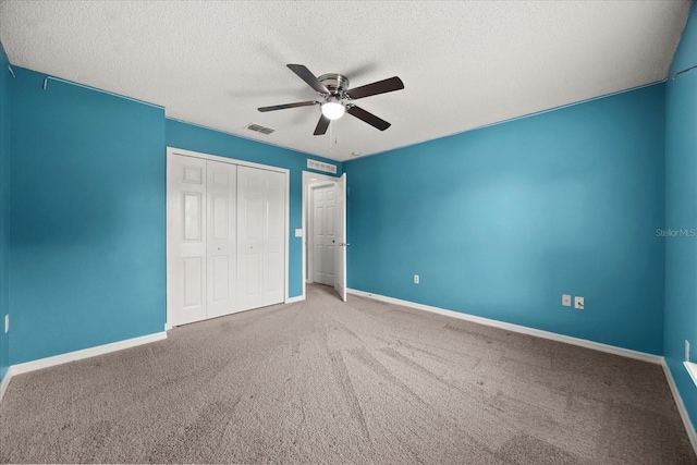 2725 White Magnolia Loop, Clermont, FL 34711 - unfurnished bedroom featuring a textured ceiling, carpet flooring, a closet, and a ceiling fan