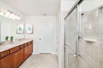1512 Mumbai Way, Kissimmee, FL 34747 - full bathroom featuring double vanity, a stall shower, and tile patterned flooring