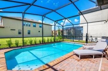 1512 Mumbai Way, Kissimmee, FL 34747 - outdoor pool featuring a patio and glass enclosure