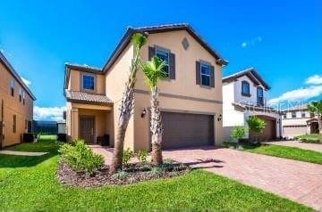1512 Mumbai Way, Kissimmee, FL 34747 - mediterranean / spanish house featuring an attached garage, stucco siding, driveway, and a front lawn