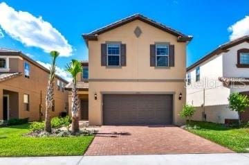 1512 Mumbai Way, Kissimmee, FL 34747 - view of front facade with decorative driveway, an attached garage, and stucco siding
