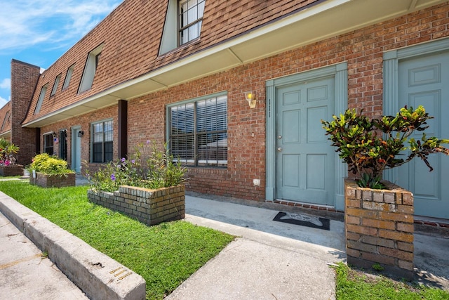 1300 Arlington Ln NE Unit 111, Palm Bay, FL 32905 - entrance to property featuring mansard roof, roof with shingles, and brick siding