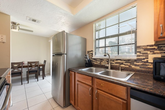 1300 Arlington Ln NE Unit 111, Palm Bay, FL 32905 - kitchen with dishwasher, range, freestanding refrigerator, dark countertops, and backsplash