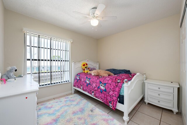 1300 Arlington Ln NE Unit 111, Palm Bay, FL 32905 - bedroom with light tile patterned floors, a textured ceiling, and a ceiling fan