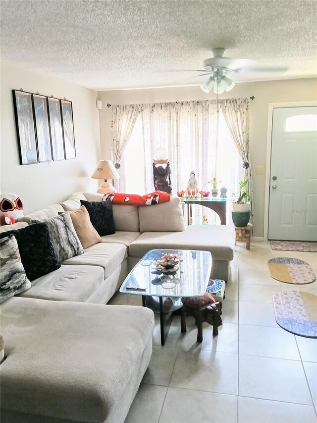 6640 121st Ave Unit 1, Largo, FL 33773 - living area featuring healthy amount of natural light, ceiling fan, light tile patterned flooring, and a textured ceiling