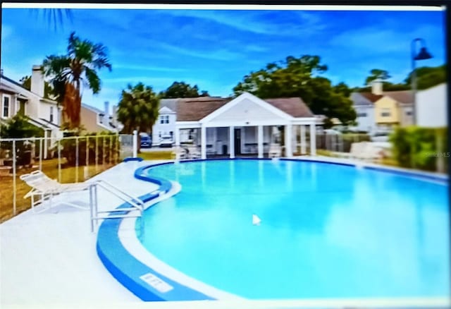 6640 121st Ave Unit 1, Largo, FL 33773 - community pool with a residential view, a patio, and an outdoor structure