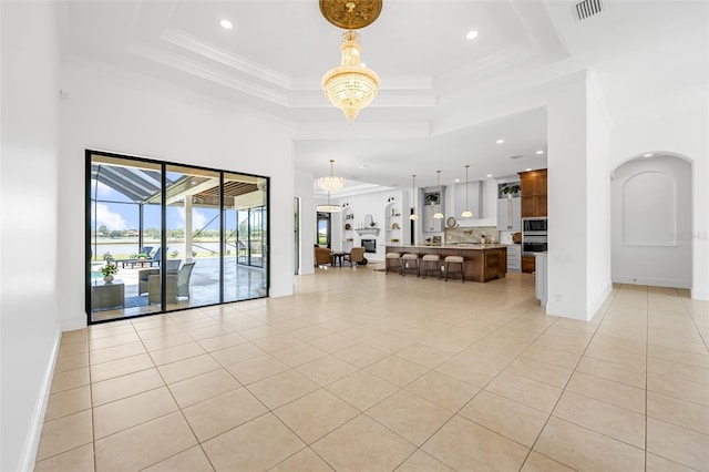 2873 Bellwind Cir, Rockledge, FL 32955 - living room featuring a chandelier, light tile patterned flooring, arched walkways, a raised ceiling, and recessed lighting